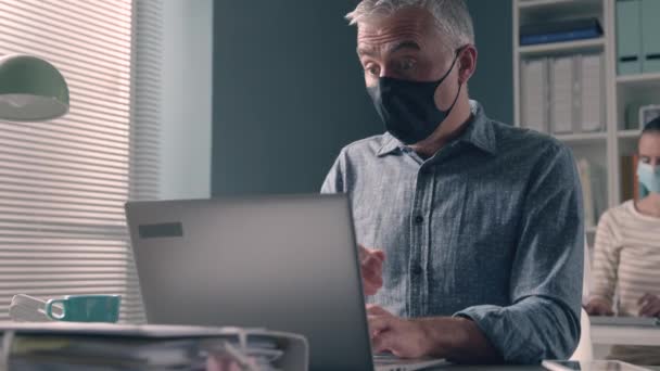 Kantoormedewerker met een gezichtsmasker en ademhalingsproblemen — Stockvideo