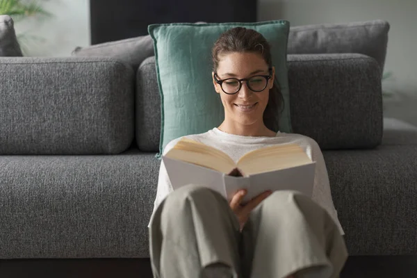 Šťastná Vyrovnaná Žena Sedící Podlaze Čtoucí Knihu Usmívá Prohlíží Stránky — Stock fotografie