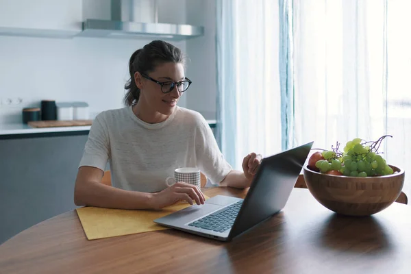 Happy Vrouw Ontbijten Keuken Online Verbinding Maken Met Haar Laptop — Stockfoto