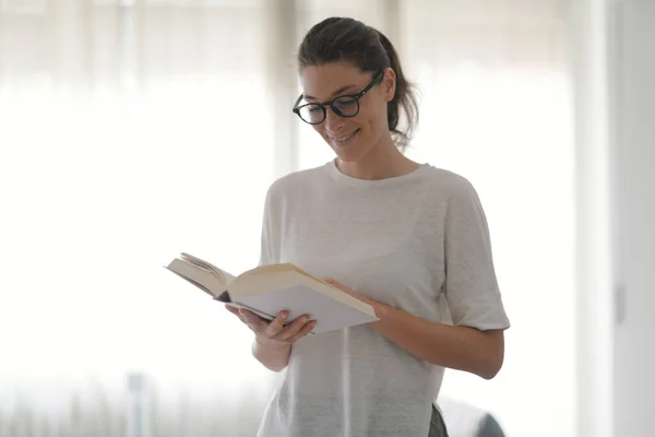 Gelukkig Glimlachende Vrouw Thuis Staan Het Lezen Van Een Boek — Stockfoto