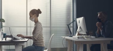 Coronavirus önleme ve ofisteki sosyal mesafeler: iş adamları güvenlik mesafesini koruyorlar ve yüz maskesi takıyorlar, koronavirüs önleme kavramı