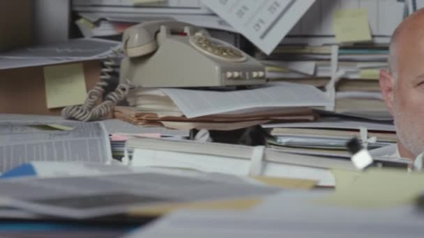 Sad stressed businessman under a lot of paperwork — Stock Video