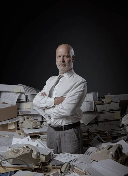 Selbstbewusster Seriöser Geschäftsmann Posiert Mit Verschränkten Armen Seinem Chaotischen Büro — Stockfoto