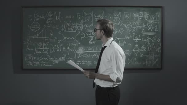 Besviken matematiker raderar sitt arbete på tavlan — Stockvideo