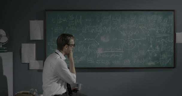 Tahtada matematik formüllerini inceleyen zeki bir matematikçi. — Stok video