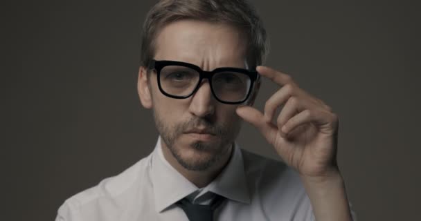 Homem olhando para a câmera e segurando óculos — Vídeo de Stock