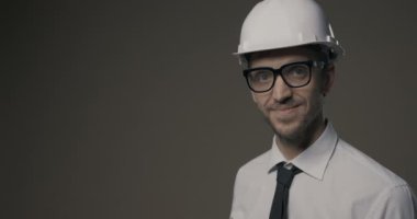 Gülümseyen mimar elinde bir model ev tutuyor.