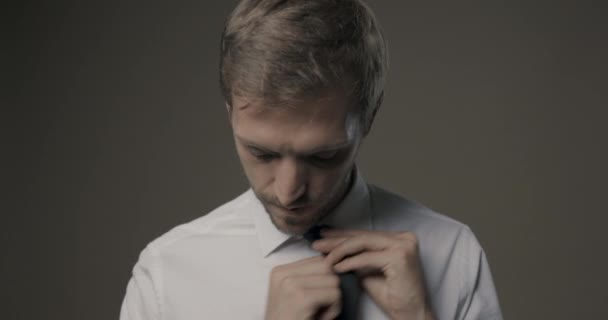 Selbstbewusster junger Mann justiert seine Krawatte — Stockvideo