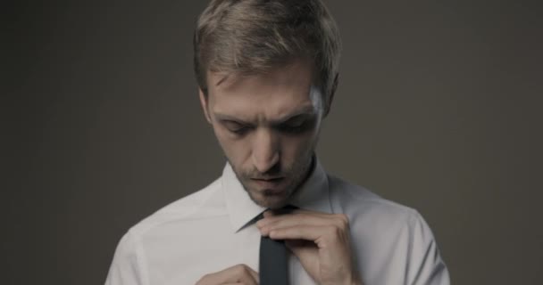 Уверенный молодой человек регулирует галстук — стоковое видео