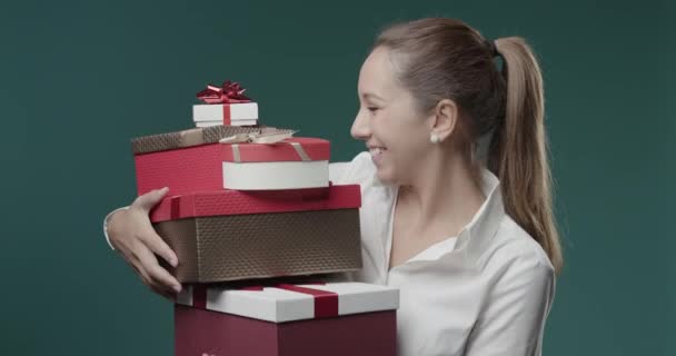 Happy young woman holding a lot of gift boxes — Stock Video