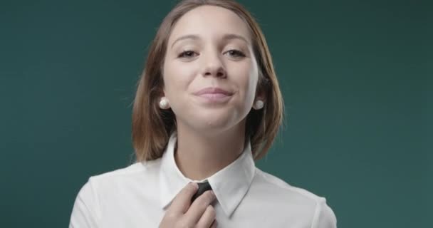 Уверенная девушка позирует и настраивает галстук — стоковое видео