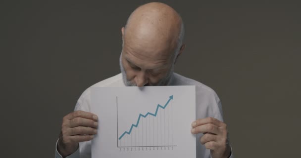 Hombre de negocios feliz sosteniendo un gráfico financiero exitoso — Vídeo de stock