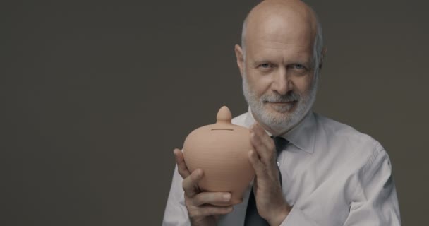 Confident businessman holding a money box — Stock Video