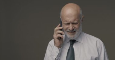 Orta yaşlı bir adam akıllı telefonunu kullanmakta zorlanıyor ve sorun yaşıyor.