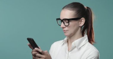 Telefonuyla konuşan ve gülümseyen bir kadın.