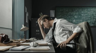 Zeki genç matematikçi ofis masasında oturup ödevlerini gözden geçiriyor ve yeni formüller üzerinde çalışıyor.