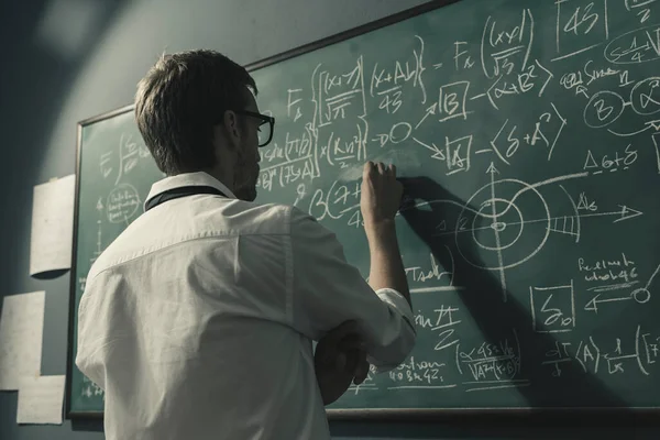 수학자가 칠판에 공식을 그리면서 합니다 문제를 해결하고 새로운 이론을 발견하고 — 스톡 사진