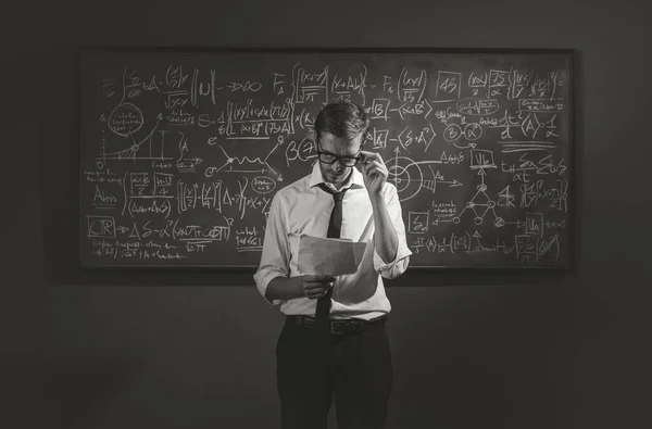 若い数学教授が黒板の前に立ち 学術研究の概念を説明することを確信する — ストック写真