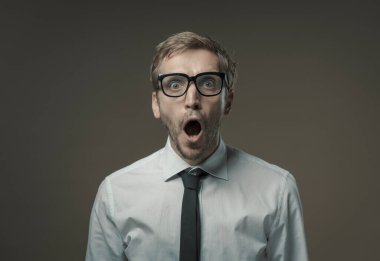 Gözlüklü genç işadamı kameraya bakıyor ve nefes nefese. Şok olmuş ve korkmuş.