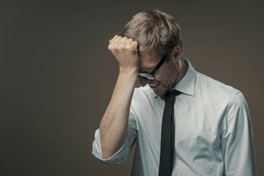 Stresli bir iş adamı yüz ifadesi sergiliyor. Hatasından dolayı utanç duyuyor.