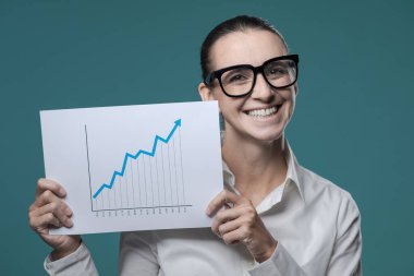 Büyüyen bir mali tabloyu elinde tutan neşeli iş kadını ve gülümseyen, başarılı bir iş konsepti.