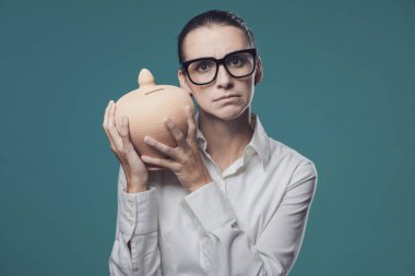 İş kadını para kutusunu sallıyor ve tasarruf, depozito ve yatırım konseptini kontrol ediyor.