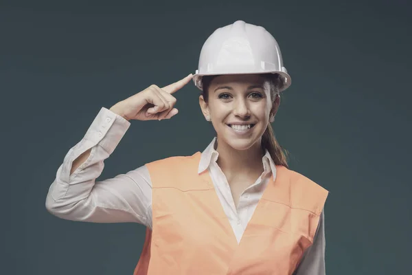 穿着安全背心 安全帽 工作安全和保护工作服的年轻女性微笑 — 图库照片