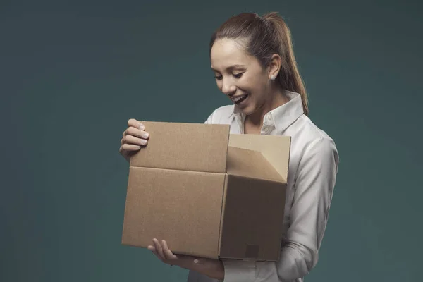 Happy woman opening a delivery box, she is happy with the product she received