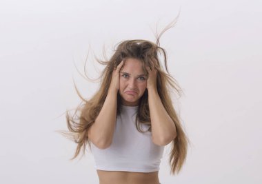 Hüsrana uğramış, kafası elinde ve dağınık saçları olan genç bir kadın. Saç problemi var.