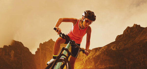 A young woman in sportswear runs with determination alongside her mountain bike in a scenic mountain landscape, symbolizing endurance, strength, and outdoor adventure. Perfect for themes of fitness, sport, healthy lifestyle, and nature exploration.