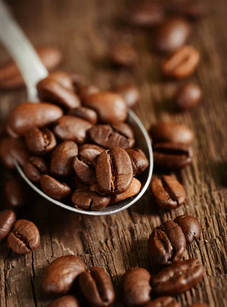 Kávová zrna v kovové lžíce — Stock fotografie