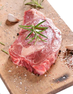 Beyaz arka plan üzerinde izole ahşap tahta üzerinde rosemary ile çiğ biftek