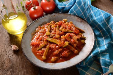 Okra dish with tomatoes. Traditional greek, romanian, bulgarian and turkish dish clipart