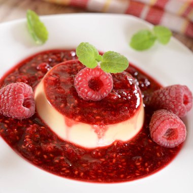 Üstte panna cotta tatlı taze ahududu ve nane yaprakları