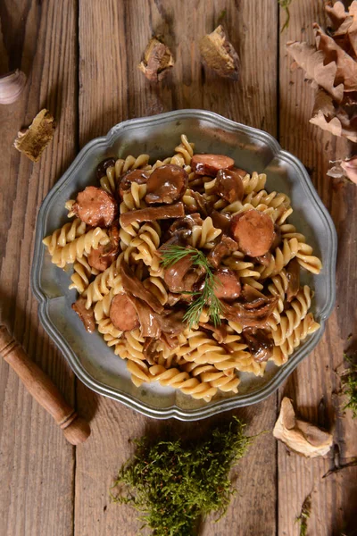 Fussili makarna mantar ve vintage metal plaka sosis