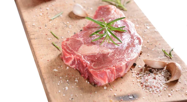 Beyaz arka plan üzerinde izole ahşap tahta üzerinde rosemary ile çiğ biftek