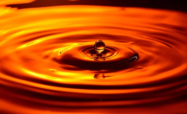 Vista Ravvicinata Delle Goccioline Che Cadono Nel Liquido Arancione — Foto Stock