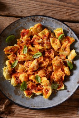 Domates sosu, peynir ve fesleğen yaprakları ile mantı