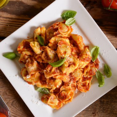 Domates sosu, peynir ve fesleğen yaprakları ile mantı