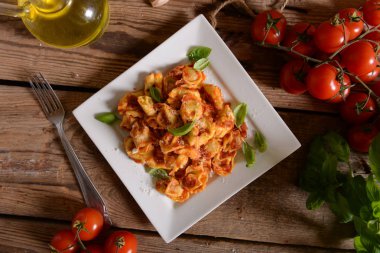 Domates sosu, peynir ve fesleğen yaprakları ile mantı