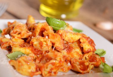 Domates sosu, peynir ve fesleğen yaprakları ile mantı