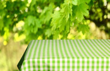 Boş tablo ile renk kareli masa örtüsü ve doğal arka plan bulanık