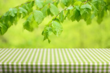Boş tablo ile renk kareli masa örtüsü ve doğal arka plan bulanık