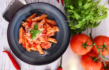 Lezzetli arabiata makarna peynir ve fesleğen yaprakları ile