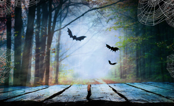 Empty wooden table with creepy Halloween background