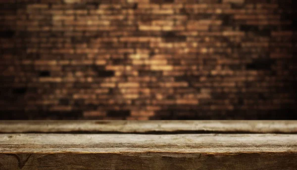 レンガの壁の背景に空の木製テーブル — ストック写真