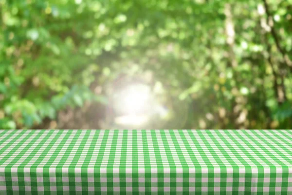 Lege Tabel Met Kleur Geruit Tafelkleed Natuurlijke Achtergrond Wazig — Stockfoto