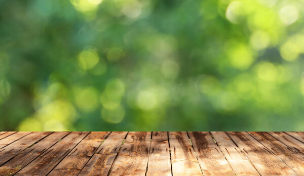 Пустой деревянный стол с размытым естественным фоном
