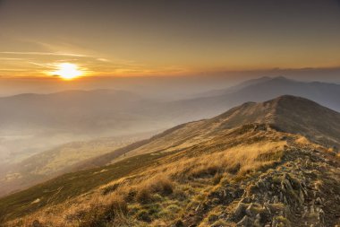 görkemli Puslu Dağlar içinde güzel gün batımı