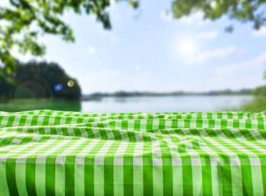 Boş tablo ile damalı masa örtüsü ve doğal arka plan bulanık